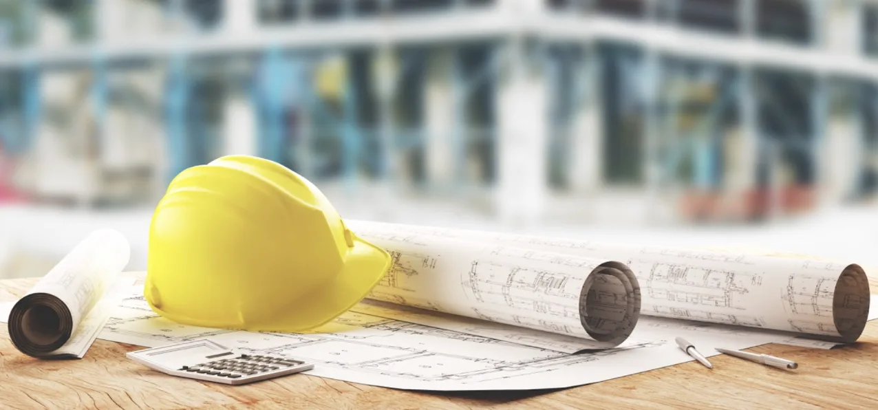 Tavole di cantiere, elmetto protettivo e calcolatrice